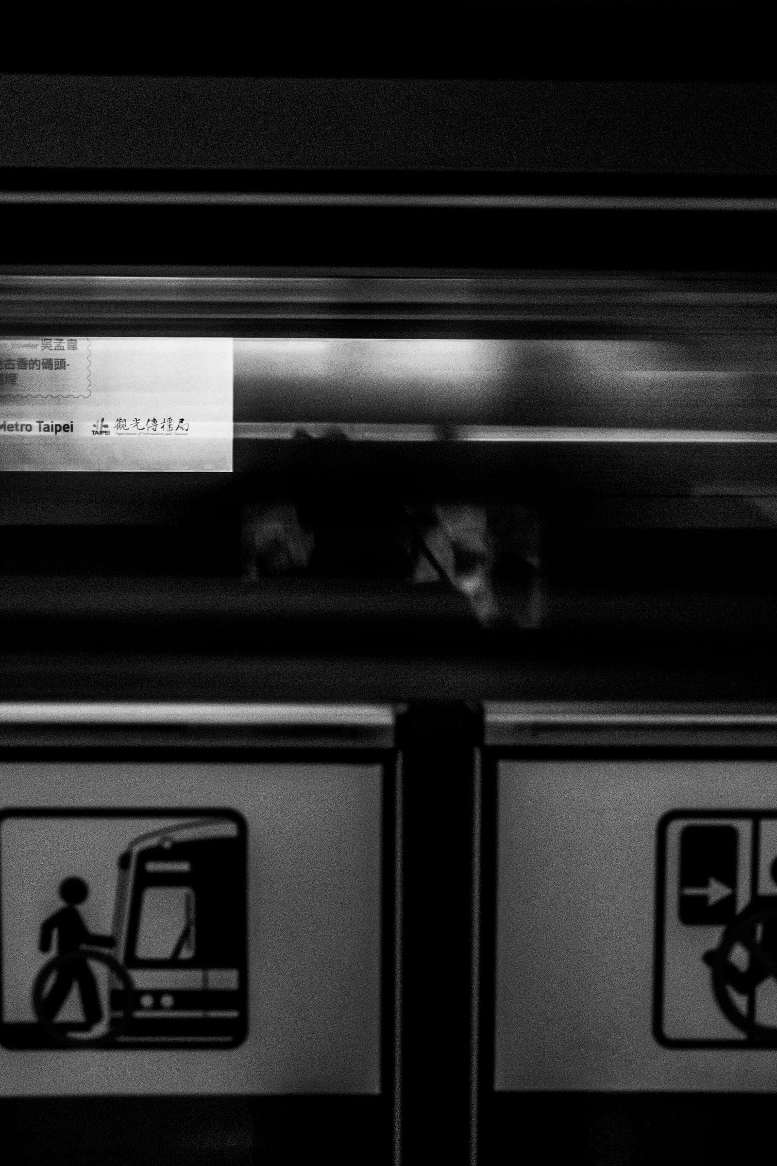 A Taipei metro train passing the platform in motion blur.